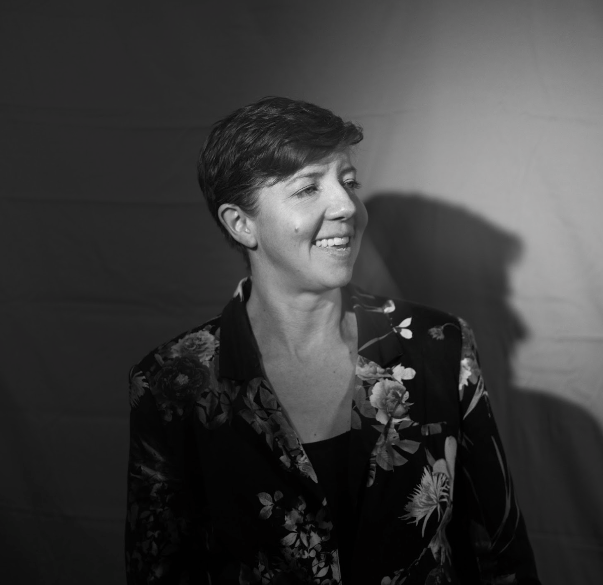 A photo of Juniper McKelvie, wearing a floral blazer, in black and white A photo of Juniper McKelvie, wearing a floral blazer, in black and white